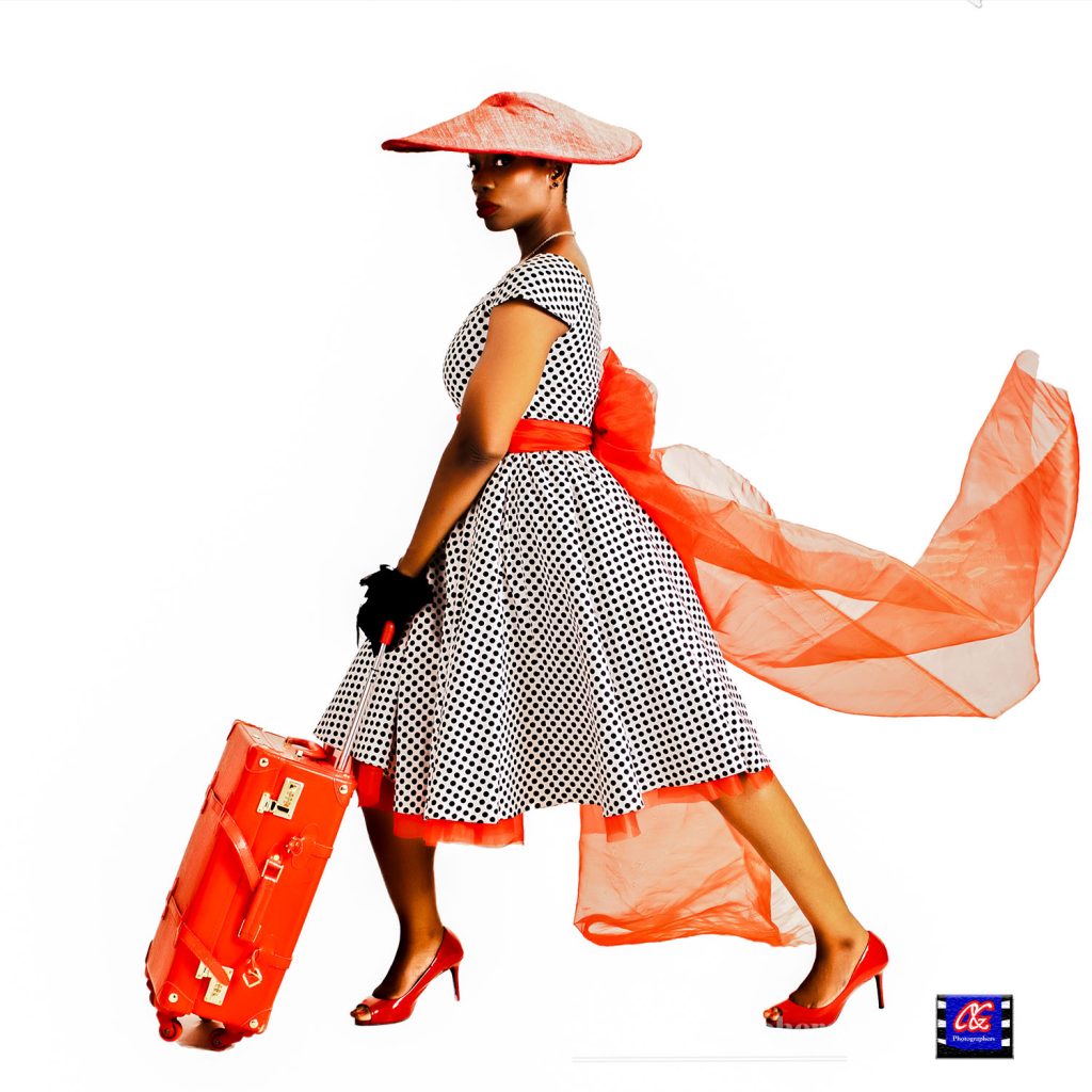 A Fashion photography portrait of a female model walking with a travelling briefcase. Photography by C&G Photographers