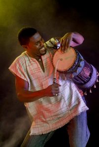 african drummer playing traditional drum with expressive performance