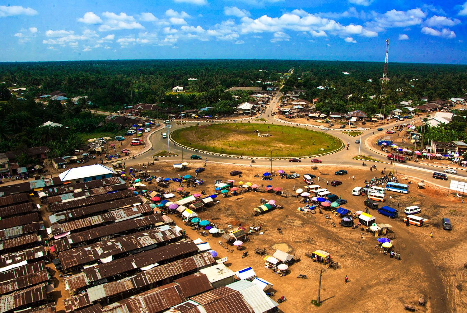 Drone aerial view of a large roundabout in Akwa Ibom Nigeria with vehicles and roadside trading activity