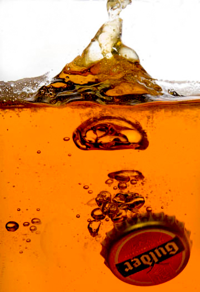 Dynamic beer splash captured underwater showcasing bubbles and motion in product photography.