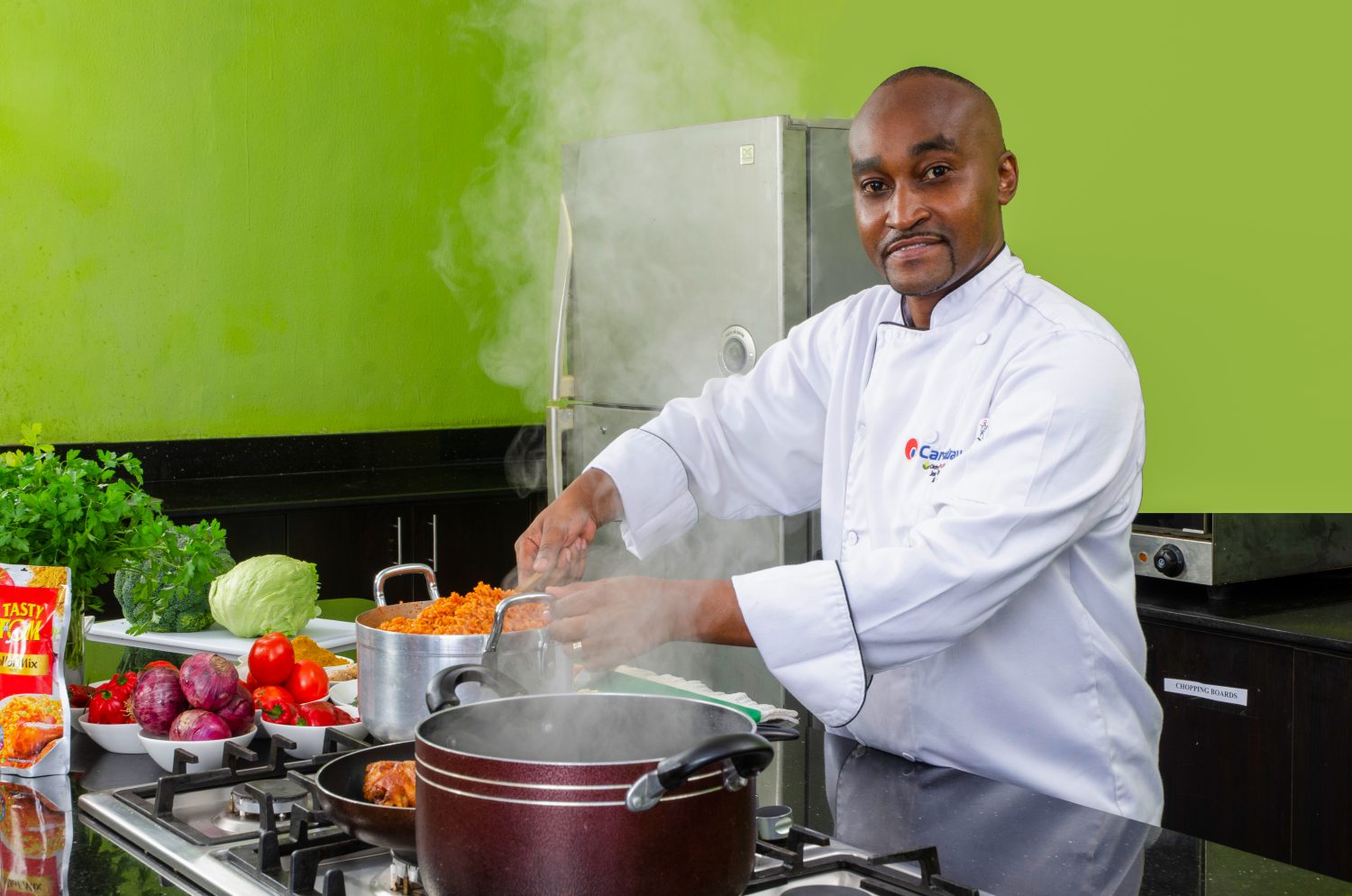 Chef preparing jollof rice in a modern kitchen setting.