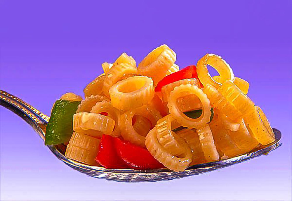 Creative food photography of pasta and vegetables styled on a spoon with a vibrant background in Lagos Nigeria