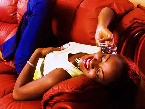 Lifestyle advertising photo of a happy woman relaxing on a red couch in Lagos Nigeria