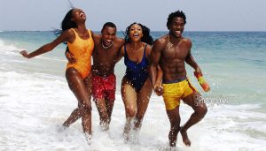 Lifestyle beach advertising photography of friends running in the ocean in Lagos Nigeria