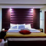luxury hotel bedroom with king size bed and illuminated headboard
