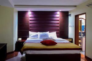 luxury hotel bedroom with king size bed and illuminated headboard