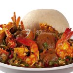 Nigerian seafood pepper soup with prawns, snail and eba served on a plate, professional food photography in Lagos Nigeria