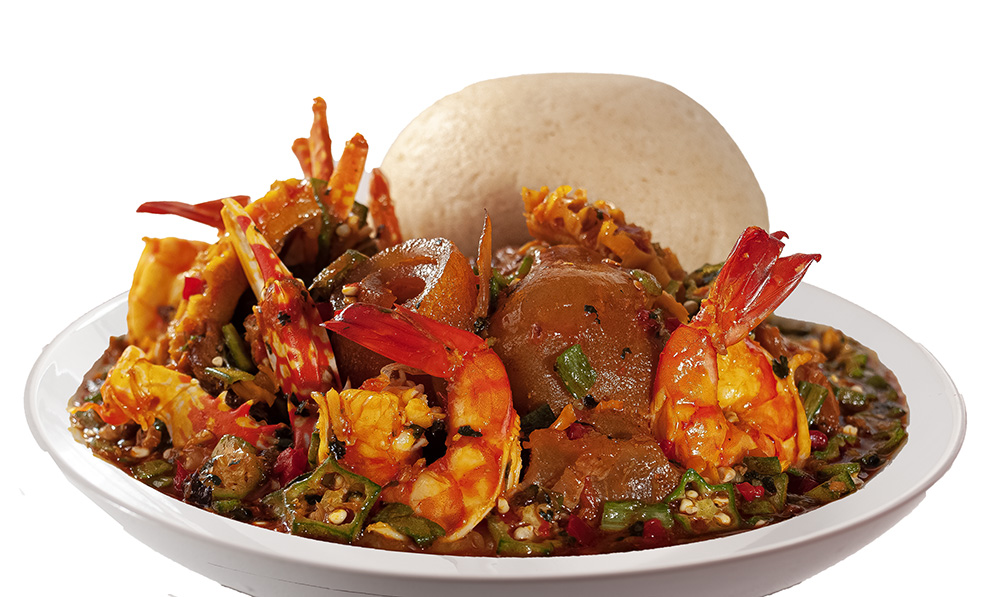 Nigerian seafood pepper soup with prawns, snail and eba served on a plate, professional food photography in Lagos Nigeria