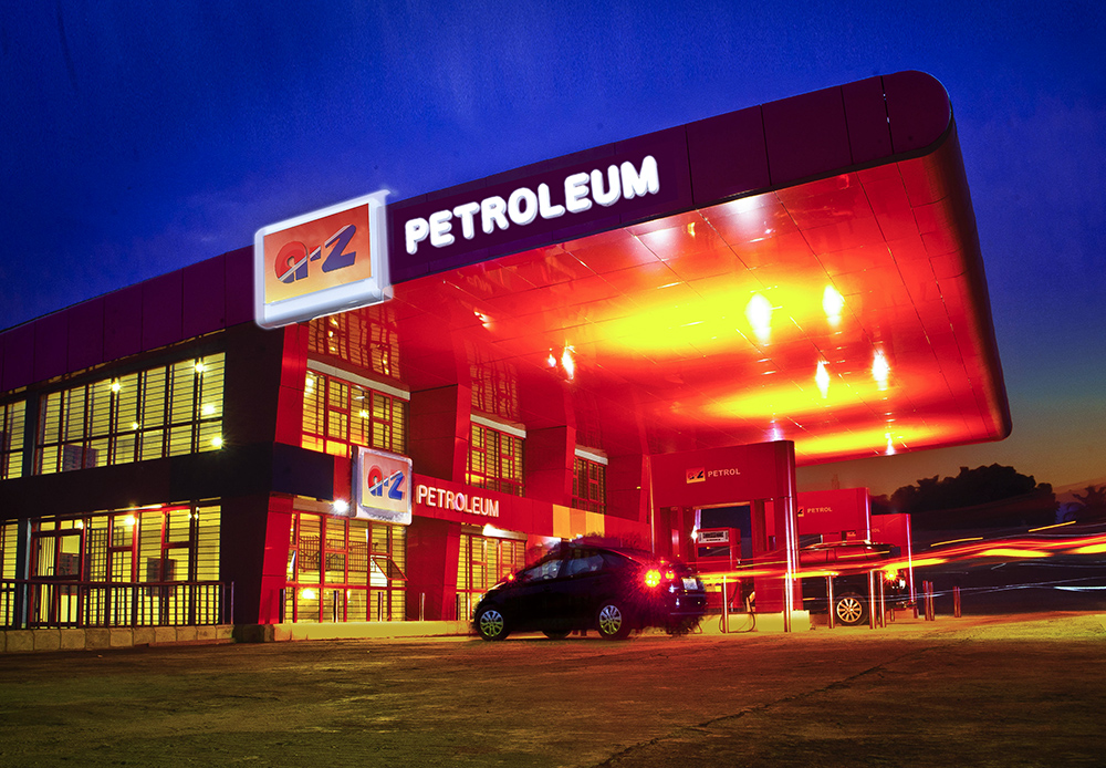 Commercial night photograph of a petrol station featuring architectural lighting and long exposure light trails.
