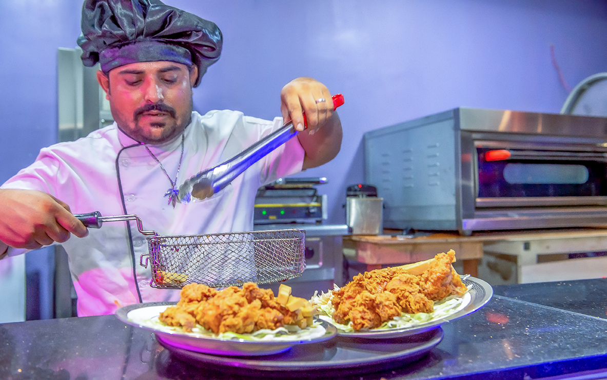 Chef preparing fried chicken in a commercial kitchen captured for restaurant food advertising photography in Lagos