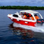 speed boat transporting passengers on river with life jackets