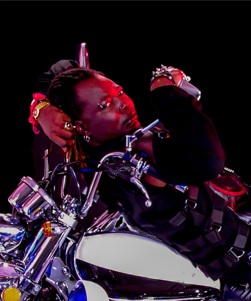 Charly Boy posing on a motorcycle for Legend Stout advertising photography