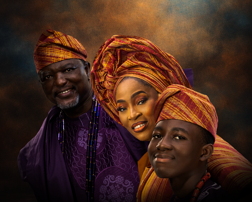 Nigerian family in coordinated Yoruba traditional attire posing together for a professional studio family portrait.