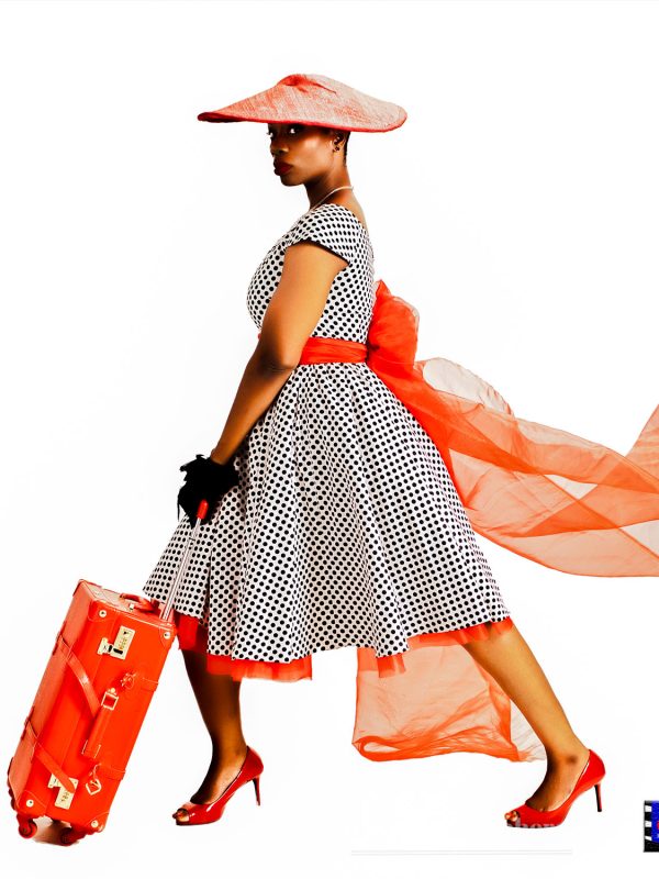 A Fashion photography portrait of a female model walking with a travelling briefcase. Photography by C&G Photographers