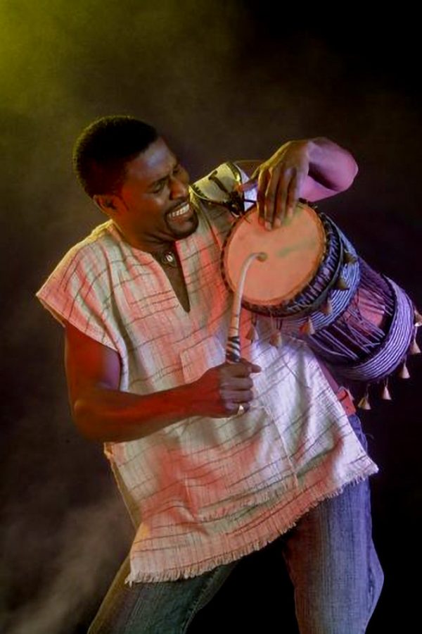 african drummer playing traditional drum with expressive performance